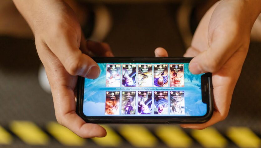 Hands holding a smartphone displaying a mobile game